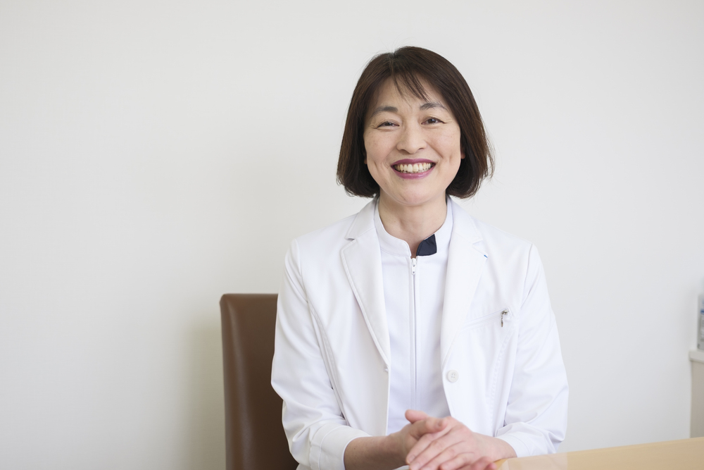 担当医師 大部幸が白衣で微笑んでいる様子